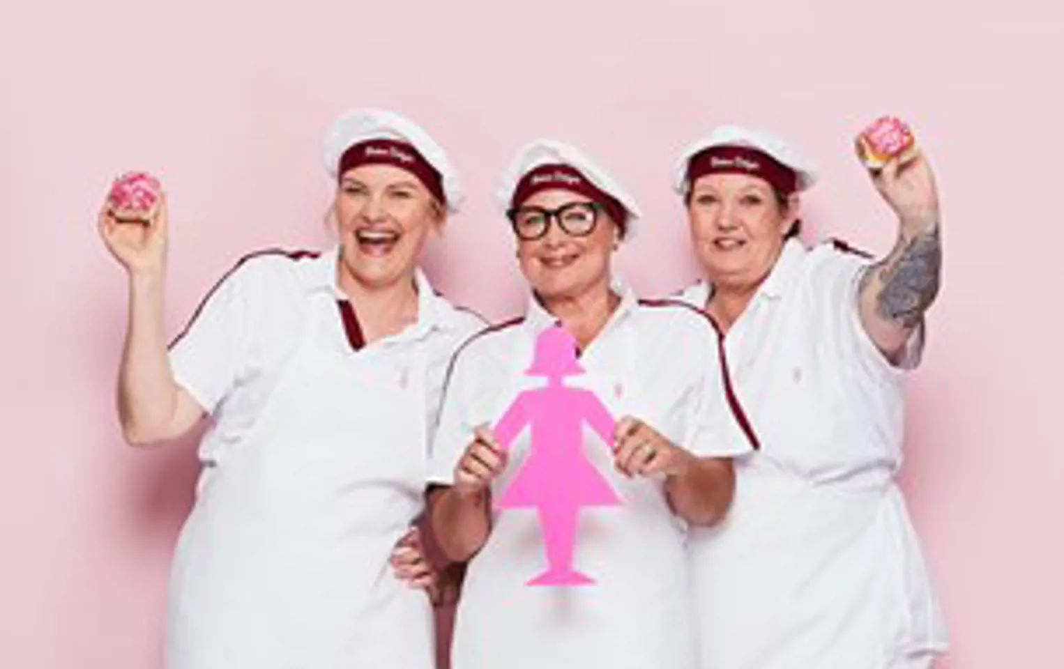 Photo of three Bakers Delight franchisees, Donna, Holly and Kim, who are smiling and dressed in white uniform and caps