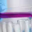 Close up of someone in a pathology lab pouring a liquid into test tubes