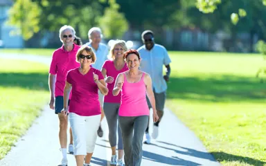 A group of people in activewear walking along a path