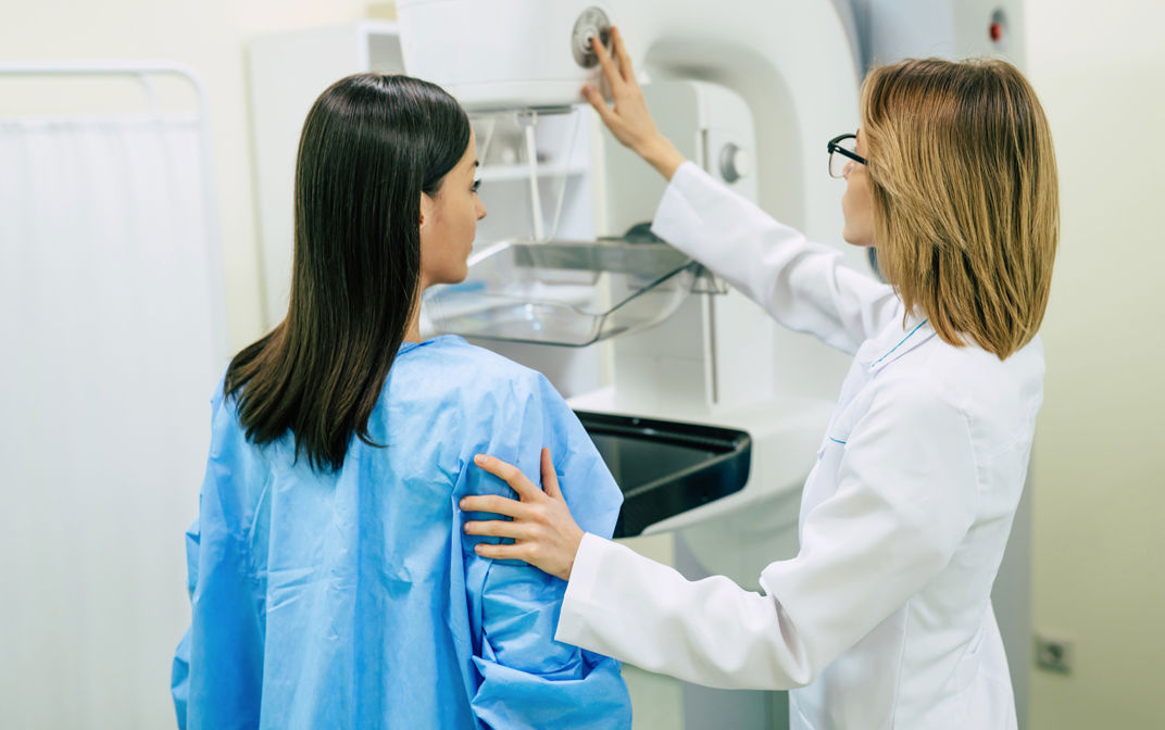 A woman is having a mammography examination with a professional female doctor