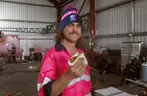 pink tradie eating sausage sizzle