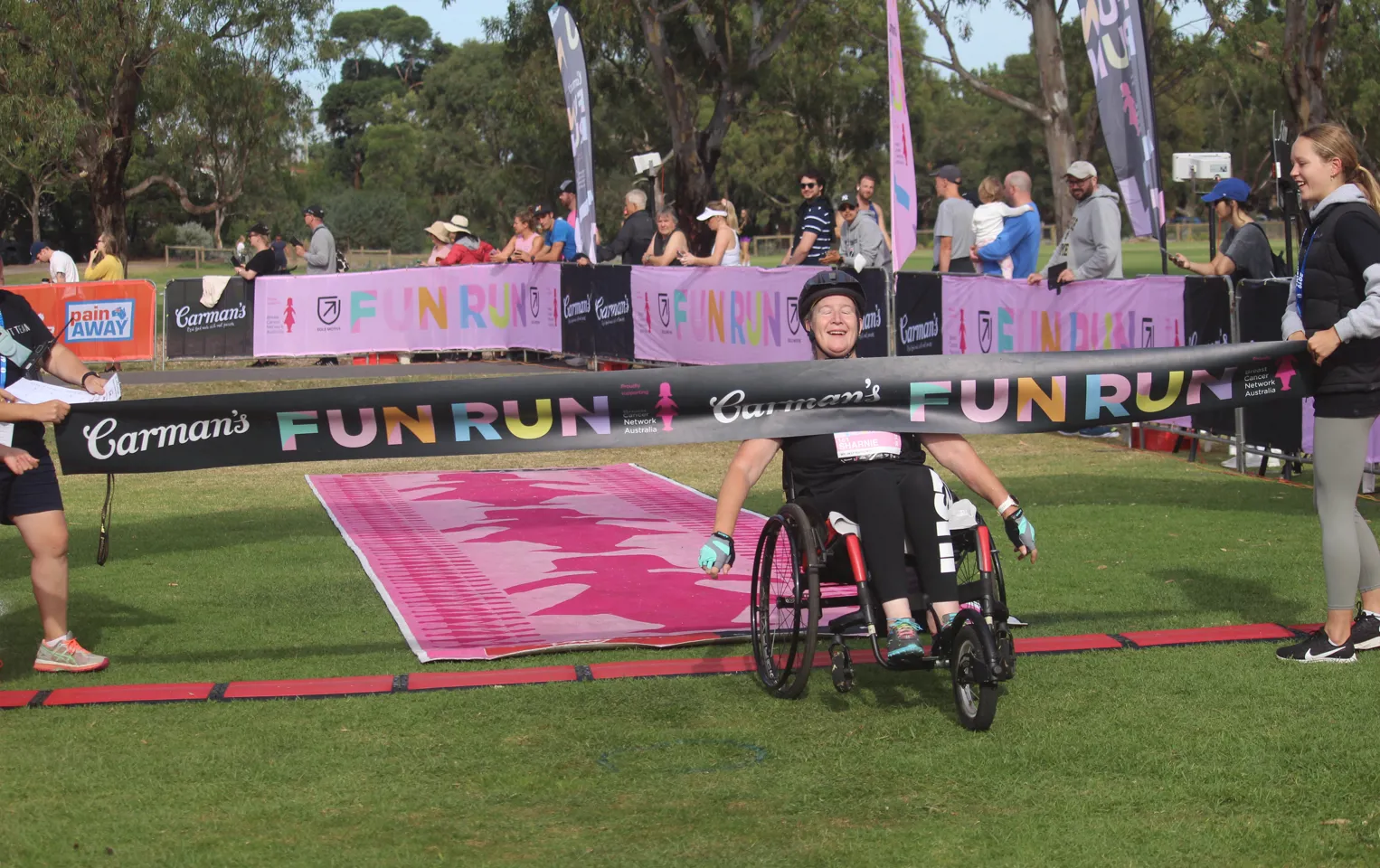 Photo of participant in wheelchair doing through the finish line at 2023 Carman's fun run